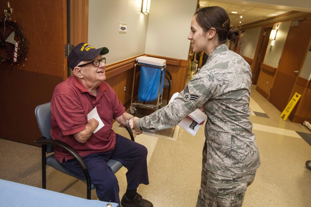 U.S. Air Force Senior Airman Dana Rhoads shakes hands with a veteran during the 15th Annual Holiday "Songfest" at the New Jersey Veterans Memorial Home at Vineland, N.J., Dec. 16, 2015. Rhoads is assigned to the New Jersey Air National Guard’s 177th Fighter Wing. New Jersey Air National Guard photo by Master Sgt. Mark C. Olsen