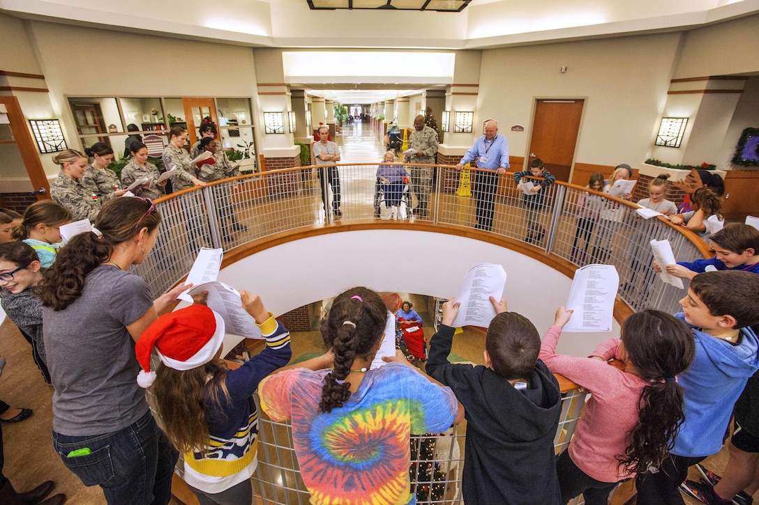 U.S. airmen sing along with fourth graders from the Seaview School in Linwood, N.J., during the 15th Annual Holiday "Songfest" at the New Jersey Veterans Memorial Home at Vineland, N.J., Dec. 16, 2015. New Jersey Air National Guard photo by Master Sgt. Mark C. Olsen