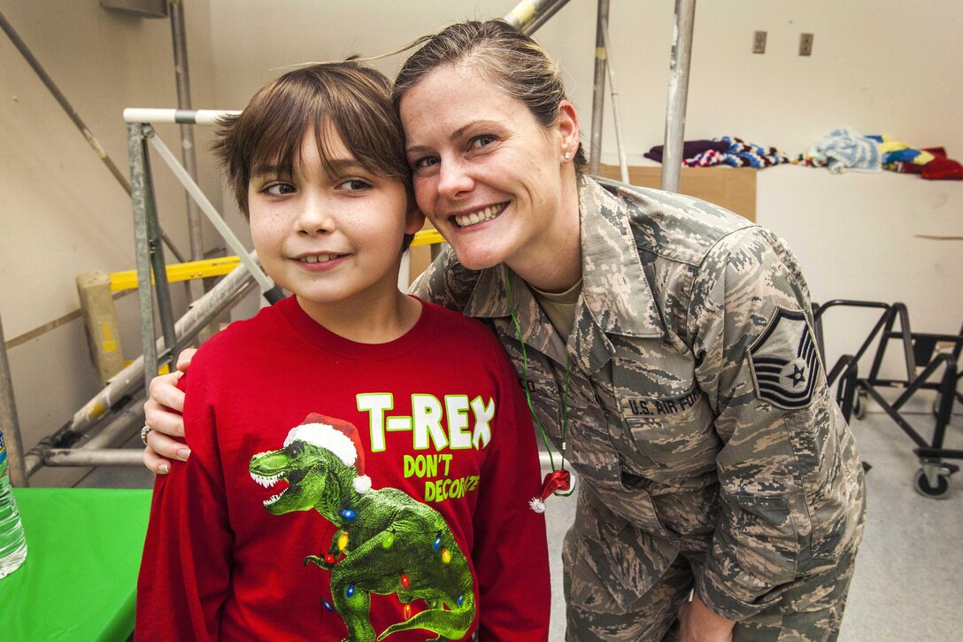 U.S. Air Force Master Sgt. Jamie Damico poses for a photograph with a student from the Seaview School in Linwood, N.J., during the 15th Annual Holiday "Songfest" at the New Jersey Veterans Memorial Home at Vineland, N.J., Dec. 16, 2015. Damico is assigned to the New Jersey Air National Guard’s 177th Fighter Wing. New Jersey Air National Guard photo by Master Sgt. Mark C. Olsen