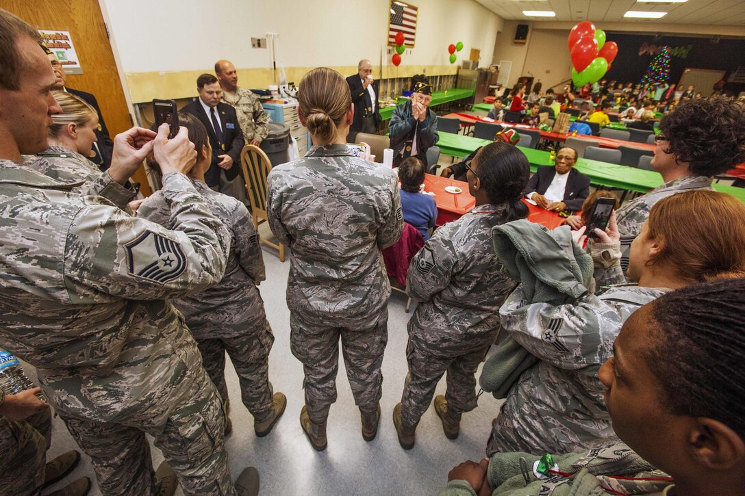 U.S. airmen listen as Howard Gant, center, an American Legion member, plays the harmonica during the 15th Annual Holiday "Songfest" at the New Jersey Veterans Memorial Home at Vineland, N.J., Dec. 16, 2015. New Jersey Air National Guard photo by Master Sgt. Mark C. Olsen