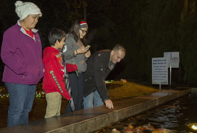 From left to right, Rhonda Kirk, program assistant with the Youth and Teen Center, Anna Kirk, and Kris Kirk, Mathew C. Perry Elementary School students, and Gunnery Sgt. Isaiah Kirk, cyber network chief with Headquarters and Headquarters Squadron at Marine Corps Air Station Iwakuni observe a Koi pond at the Hiroshima Botanical Garden in Hiroshima City, Japan, Dec. 23, 2015. The visit afforded residents the opportunity to explore various exhibits and view the festive displays at the garden.