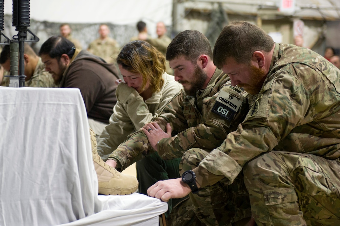 U.S. service members pay their respects during a ceremony on Bagram Airfield, Afghanistan, Dec. 23, 2015, to honor six airmen killed in a vehicle bomb attack on their patrol outside Bagram. U.S. Air Force photo by Tech. Sgt. Robert Cloys