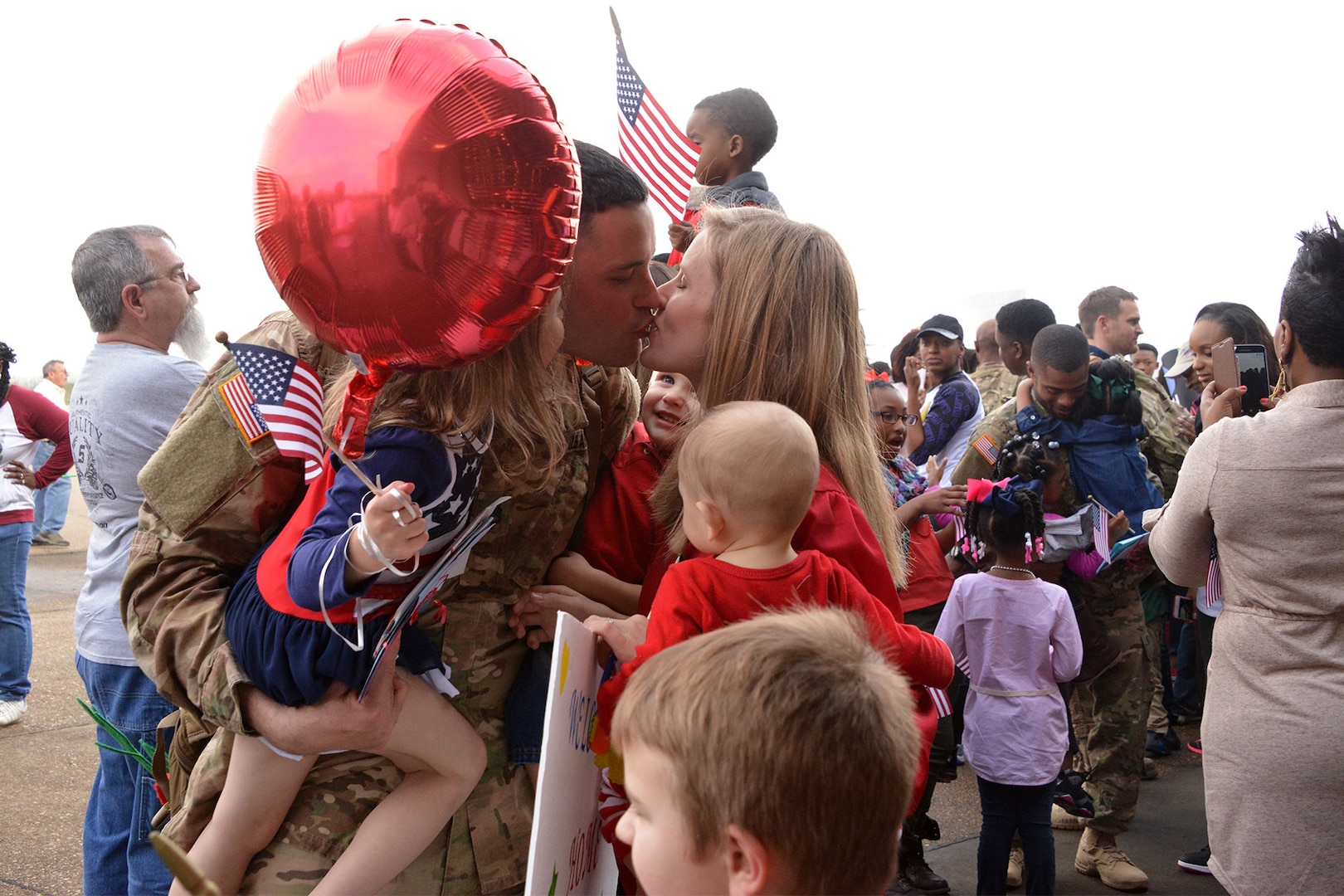 Staff Sgt. Chad Lawless, of Swartz, La., kisses his wife, Angela, and hugs his daughter, Lily, 4, and sons, Luke, 2, and Levi, 6 months. Lawless met Levi for the first time in person at the welcome-home event in Monroe, La., Dec. 24, 2015. More than 150 members of the Louisiana National Guard’s 1023rd Engineer Company, 528th Engineer Battalion just completed a 10-month deployment to Kuwait, with additional missions to Jordan, Iraq and Afghanistan.