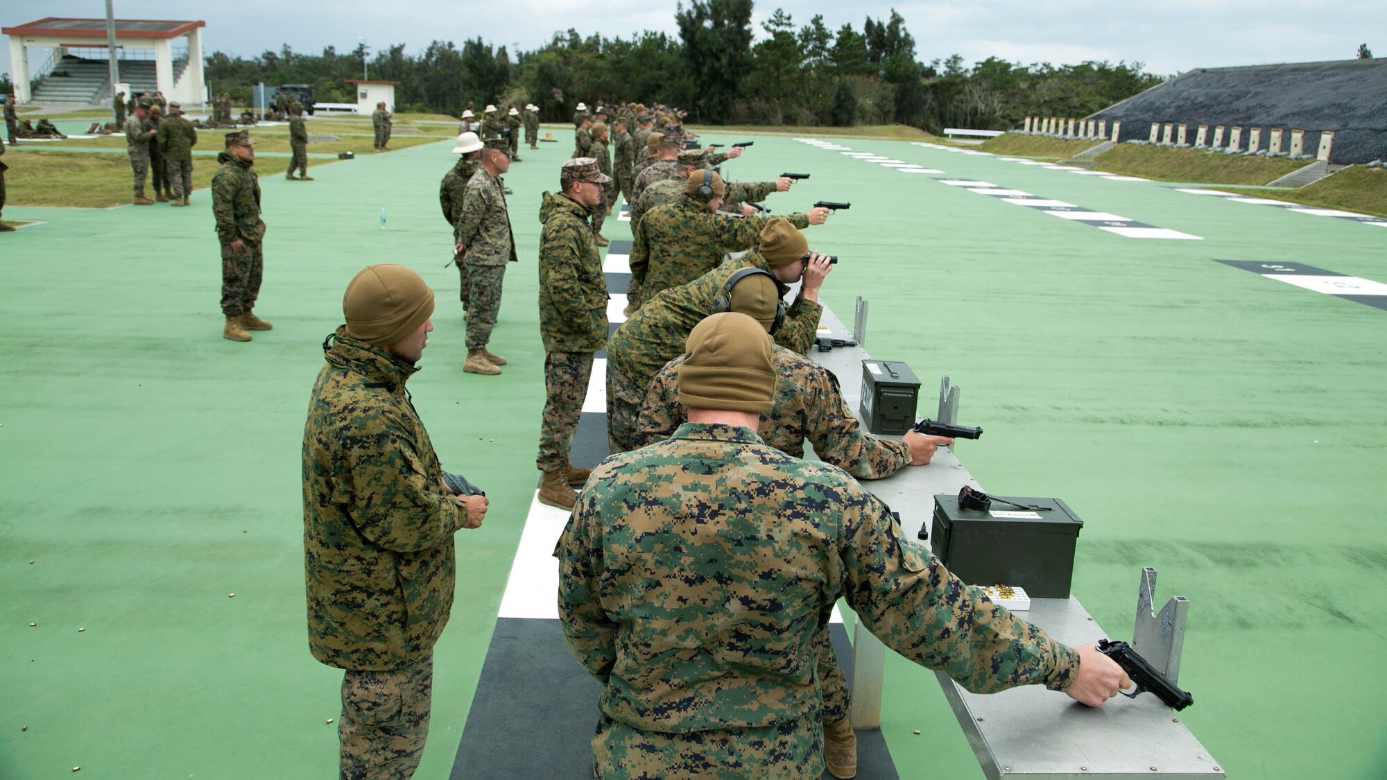 Shooters fire pistols during the Far East Division Marksmanship Match Dec. 17 aboard Camp Hansen, Okinawa, Japan. The competition consisted of classes, practice, and qualifications for both pistol and rifle marksmanship. Marine Aircraft Team 36 won the pistol marksmanship competition and 4th Marine Regiment won the rifle marksmanship competition.