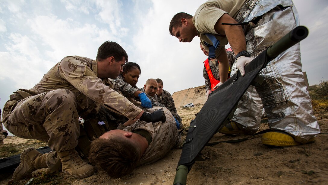 U.S. Navy and Air Force medical personnel load a simulated casualty onto a stretcher during a mass casualty exercise at an undisclosed location in Southwest Asia, Dec. 23, 2015. Canadian forces, U.S. Air Force and Army medical personnel, along with U.S. Marines and Navy corpsmen with Special Purpose Marine Air Ground Task Force – Crisis Response – Central Command, participated in the joint exercise to hone the coalition’s medical response capabilities.  SPMAGTF-CR-CC is currently deployed to the U.S. Central Command area of responsibility with a mission spanning 20 nations.