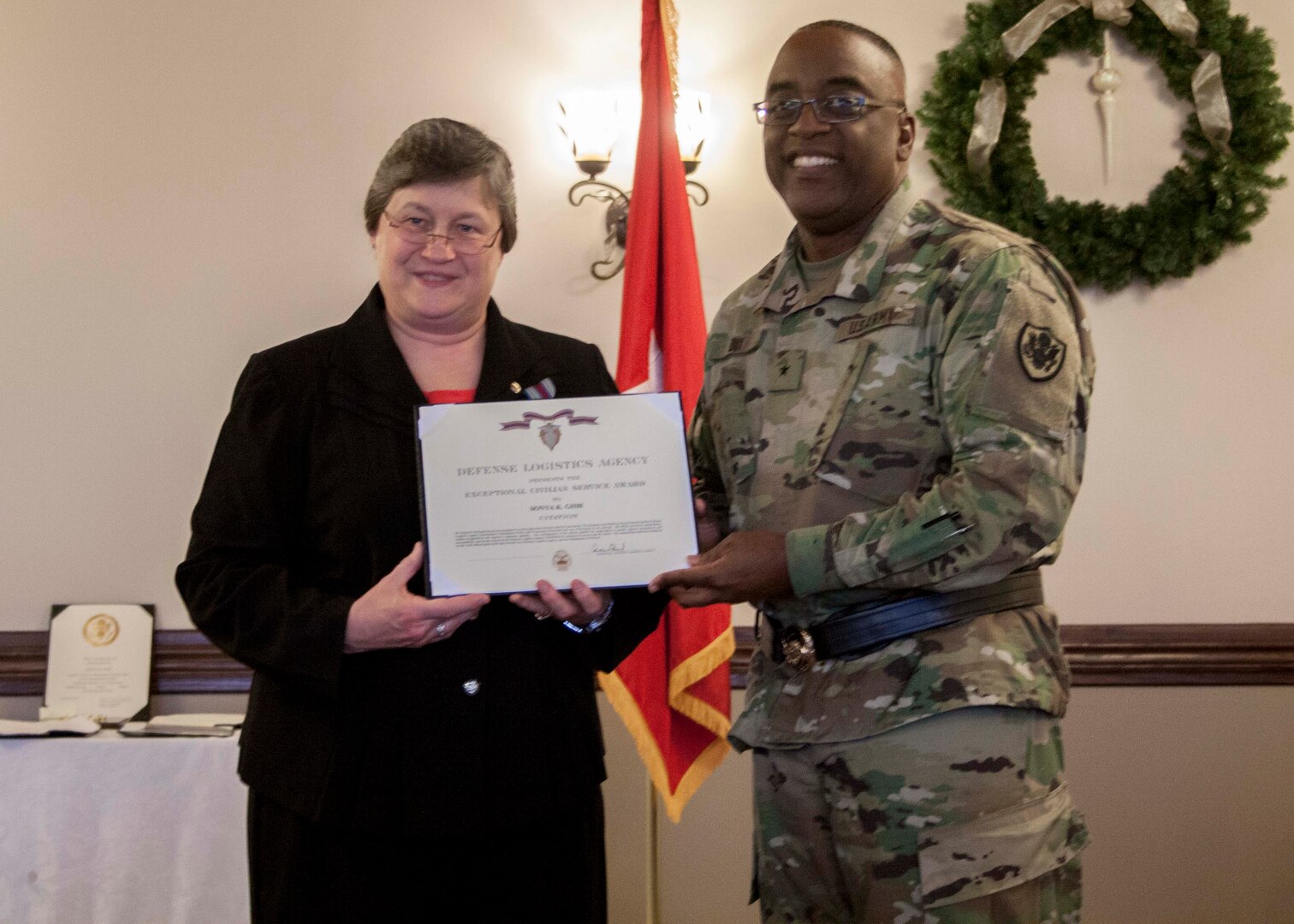 Sonya Gish, Defense Logistics Agency Distribution’s director of Distribution Policy and Processing, is presented the DLA Exceptional Civilian Service Award by DLA Distribution commander Army Brig. Gen. Richard Dix during her retirement ceremony on Dec. 22.