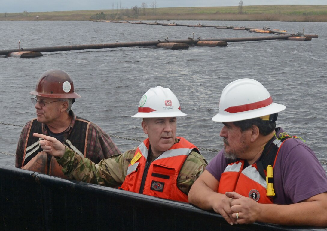 USACE South Atlantic Division's highest ranking enlisted Soldier, Command Sergeant Major Michael McIntosh, center, asks civil engineer Rolando Serrano, right, questions about dredging operations on the Cape Fear River. The federal channel needs periodic maintenance to allow container ships an unobstructed route from the Atlantic Ocean to the Port of Wilmington. (USACE photo by Hank Heusinkveld)
