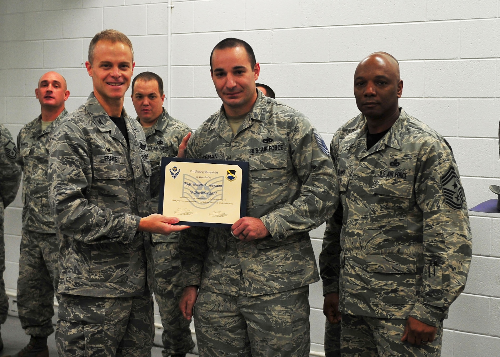 Technical Sgt. Robert Berman, 325th Maintenance Squadron nondestructive inspection craftsman, stands with Col. Derek France, 325th Fighter Wing commander, and Chief Master Sgt. Craig Williams, 325th FW command chief during a Stripes for Exceptional Performers promotion Dec. 18 at Tyndall. Berman was selected by his leadership to promote to the rank of technical sergeant for his excellent work every day. (U.S. Air Force photo by Senior Airman Dustin Mullen/Released)