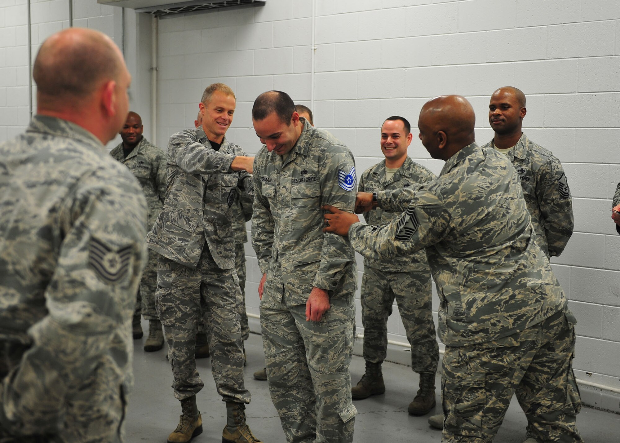 Technical Sgt. Robert Berman, 325th Maintenance Squadron nondestructive inspection craftsman, gets his new stripes tacked on by Col. Derek France, 325th Fighter Wing commander, and Chief Master Sgt. Craig Williams, 325th FW command chief during a Stripes for Exceptional Performers promotion Dec. 18 at Tyndall. The STEP program supplements existing airmen promotion programs and is designed to accommodate unique circumstances that, in the commander’s judgment, clearly warrant promotion. (U.S. Air Force photo by Senior Airman Dustin Mullen/Released)