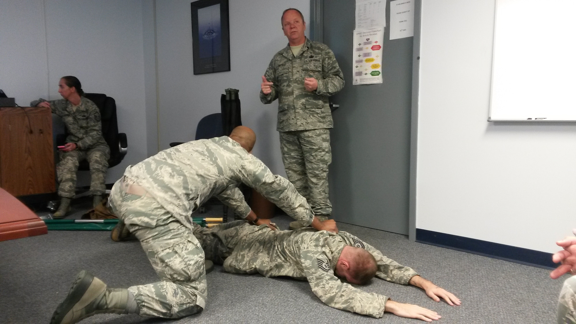 Master Sgt. Aaron Smith, 55th Combat Communications Squadron, provides instructions to Senior Airman Michael Barnes and Staff Sgt. Buck Carpenter, also assigned to the 55th CBCS, during Self-Aid/Buddy Care training to meet ancillary training requirements.  The 55th CBCS devoted two weeks at the end of 2015 as focus weeks aimed at career field-specific instructional training, mission-specific equipment training and Air Force ancillary training. (Photo by U.S. Air Force photo/Lt. Col. Lee Mumford)

