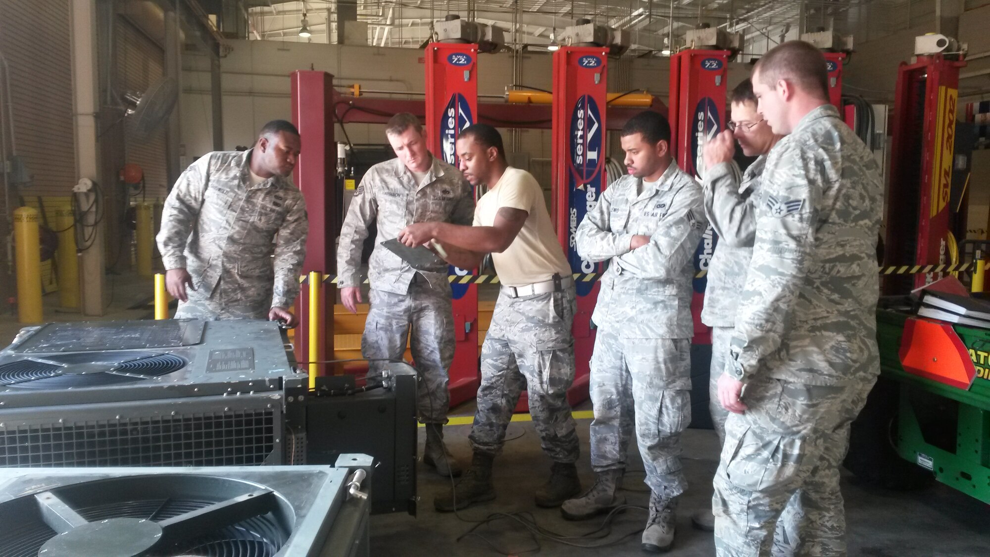 Citizen Airmen assigned to the 55th Combat Communications Squadron examine and discuss troubleshooting procedures for a field deployable environmental control unit during their Annual Tour training, Dec. 7-11. The 55th CBCS devoted two weeks at the end of 2015 as focus weeks aimed at career field-specific instructional training, mission-specific equipment training and Air Force ancillary training. (U.S. Air Force photo/Lt. Col. Lee Mumford)