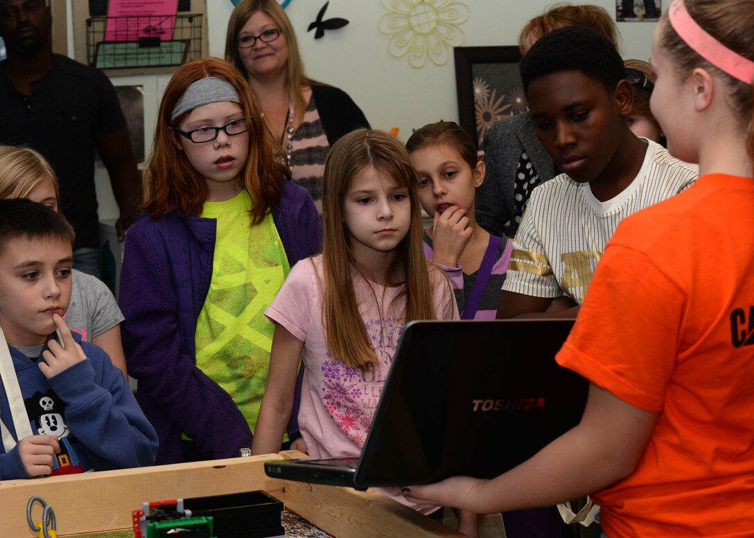 Ashton Lockhart, a robotics competitor, shows Youth Center children the tools they use for constructing toy robotics at Ellsworth Air Force Base, S.D., Dec. 21, 2015. The program used to make the robot move involves math, allowing children to learn while being entertained. (U.S. Air Force photo by Airman Donald C. Knechtel/Released)