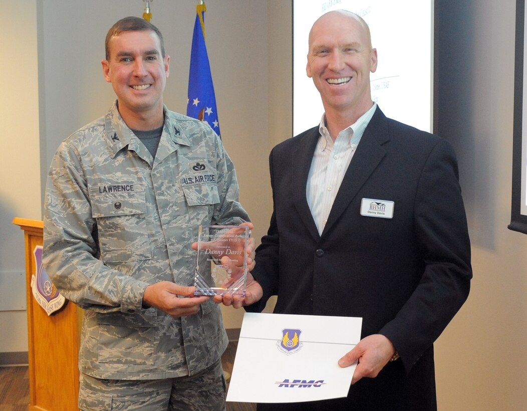 Danny Davis, Boyer Hill Military Housing property manager, receives Hill AFB's 2015 Energy Champion of the Year award from Col. Wade Lawrence, 75th Air Base Wing vice commander. Davis was recognized for his execution of a lighting project that retrofitted LED lighting in 1,082 base homes and 103 street lights saving the installation $50,500 annually. (U.S. Air Force photo by Todd Cromar)