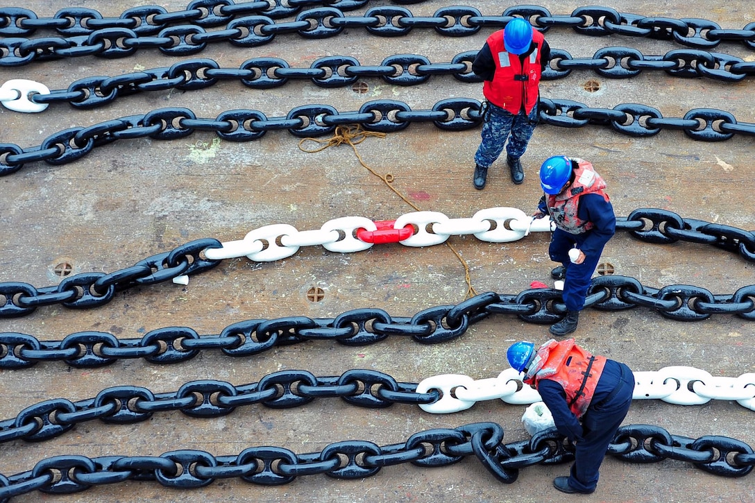 U.S. sailors assigned to the USS Blue Ridge deck department touch up the paint on the anchor chain on a floating barge during preservation operations at Commander, Fleet Activities Yokosuka, in Yokosuka, Japan, Dec. 23, 2015. U.S. Navy photo by Mass Communication Specialist 3rd Class Liz Dunagan