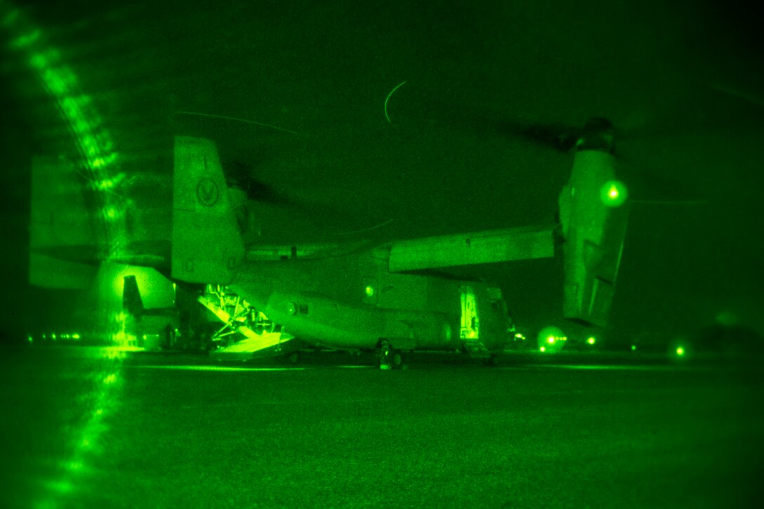 As seen through a night-vision device, U.S. Marines prepare an MV-22 Osprey before a tail gun live-fire exercise in an undisclosed location in Southwest Asia, Dec. 20, 2015. U.S. Marine Corps photo by Lance Cpl. Clarence Leake