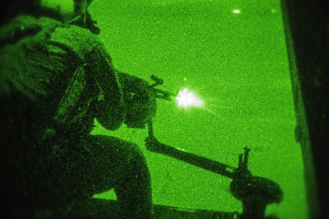 As seen through a night-vision device, U.S. Marine Corps Sgt. Joseph Michael Wren fires an M240 Bravo machine gun during a tail gun live-fire exercise in an undisclosed location in Southwest Asia, Dec. 20, 2015. Wren is a crew chief assigned to Marine Medium Tiltrotor Squadron 268, Special Purpose Marine Air-Ground Task Force-Crisis Response-Central Command. U.S. Marine Corps photo by Lance Cpl. Clarence Leake