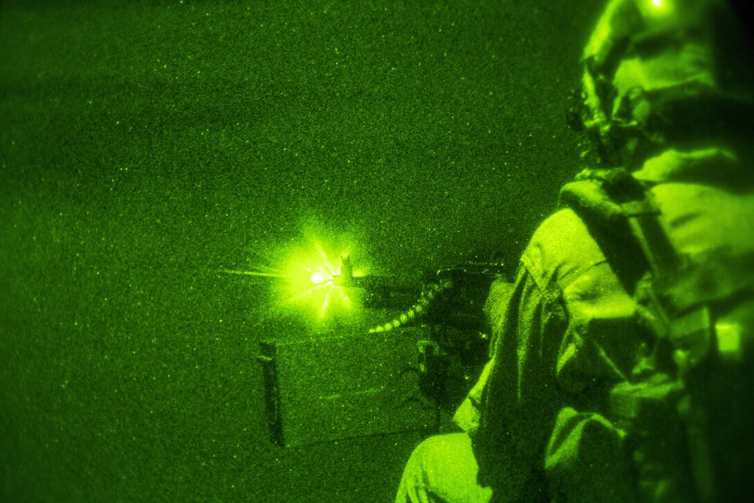 As seen through a night-vision device, U.S. Marine Corps Lance Cpl. Kirk Goldsmith fires an M240 Bravo machine gun during a tail gun live-fire exercise in an undisclosed location in Southwest Asia, Dec. 20, 2015. Goldsmith is assigned to Marine Medium Tiltrotor Squadron 268, Special Purpose Marine Air-Ground Task Force-Crisis Response-Central Command. U.S. Marine Corps photo by Lance Cpl. Clarence Leake 