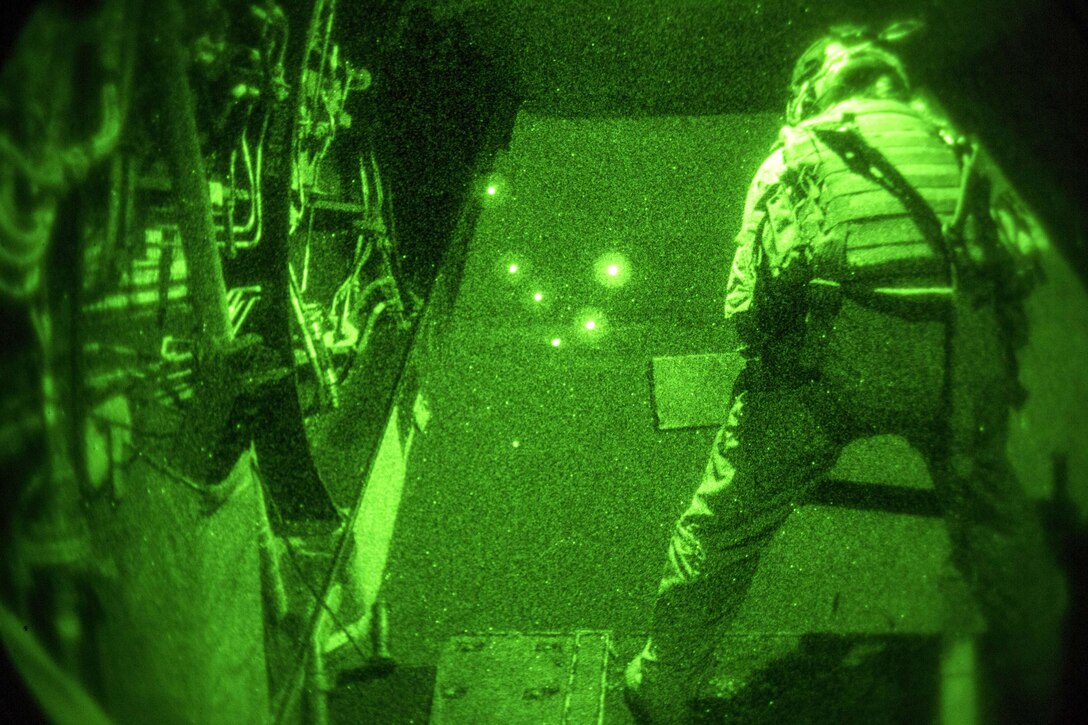 As seen through a night-vision device, U.S. Marine Corps Sgt. Jodi Esp scans for simulated targets during a tail gun live-fire exercise in an undisclosed location in Southwest Asia, Dec. 20, 2015. Esp is a crew chief assigned to Marine Medium Tiltrotor Squadron 268, Special Purpose Marine Air-Ground Task Force-Crisis Response-Central Command. U.S. Marine Corps photo by Lance Cpl. Clarence Leake 