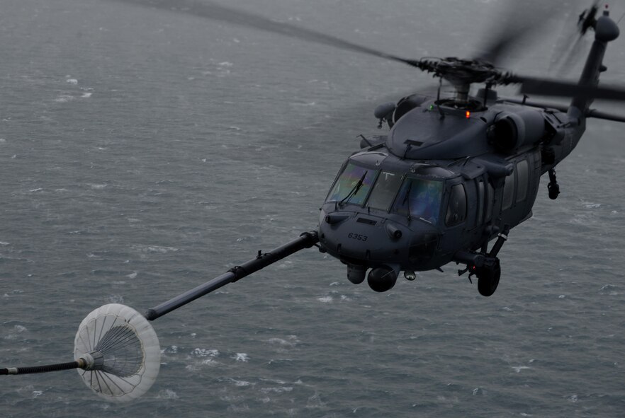 A U.S. Air Force HH-60G Pave Hawk helicopter approaches the air-refueling pod of an MC-130J Commando ll assigned to RAF Mildenhall, England while conducting a training mission Dec. 21, 2015, over the Norfolk Sea. The Pave Hawk has the capability to conduct day or night operations into hostile environments to recover downed aircrew or other isolated personnel during war. (U.S. Air Force photo by Senior Airman Victoria H. Taylor/Released) 