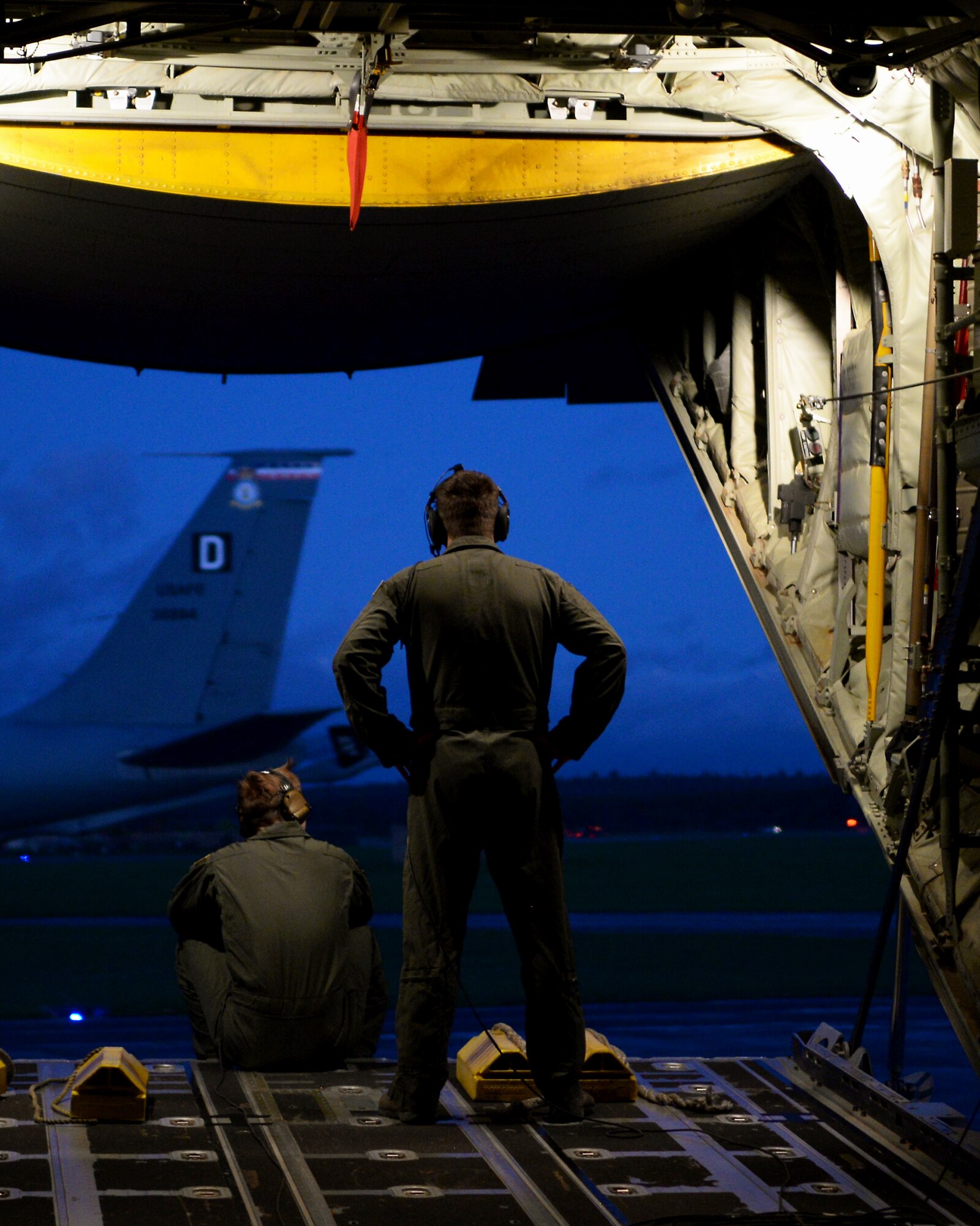 U.S. Air Force Staff Sgt. Tristian Lyons, right, and Senior Airman Nicholas Brunjes, left, both 67th Special Operations Squadron MC-130J Commando ll loadmasters, sit on the ramp of a parked MC-130J Commando ll Dec. 21, 2015, on RAF Lakenheath, England. Utilizing night vision goggles, the Commando ll can penetrate potentially hazardous areas to resupply of special operations forces via airdrop or air-land operations, and conduct long range refueling operations of vertical lift assets. (U.S. Air Force photo by Senior Airman Victoria H. Taylor/Released)