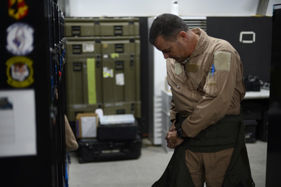 U.S. Air Force Brig. Gen. Daniel Orcutt, 380th Air Expeditionary Wing commander, attaches his g-suite prior to a Christmas morning combat sortie at an undisclosed location in Southwest Asia, Dec. 25, 2015. The g-suite provided pressure on the legs and abdomen ensure proper blood flow to the heart and brain, allowing pilots to sustain flight for a longer period of time while encountering gravitational forces. 