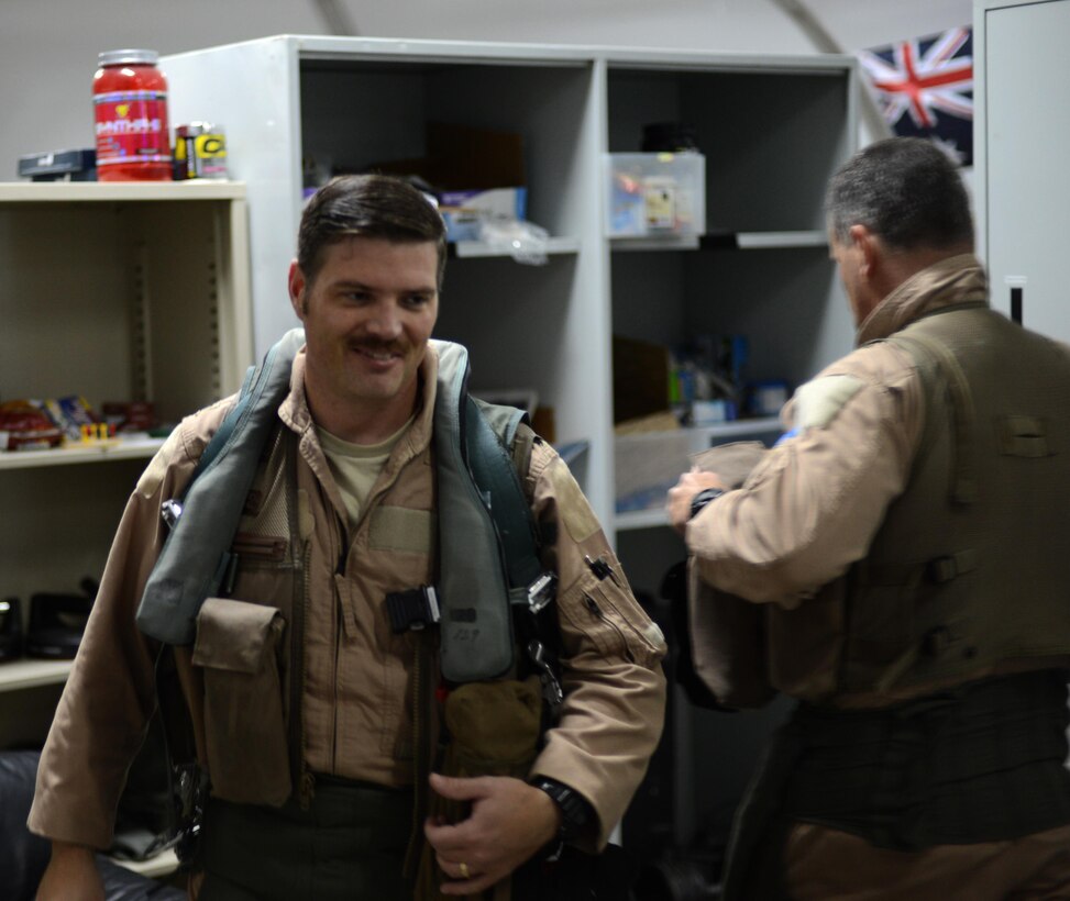 U.S. Air Force Lt. Col. Christopher, 380th Air Expeditionary Wing weapon system officer, walks past Brig. Gen. Daniel Orcutt, 380th AEW Commander, as he prepares for a Christmas Day flight at an undisclosed location in Southwest Asia, Dec. 25, 2015. Christopher’s role as a WSO required him to monitor aircraft or weapons status and possible threats during flight. (U. S. Air Force photo by Tech. Sgt. Frank Miller/Released)