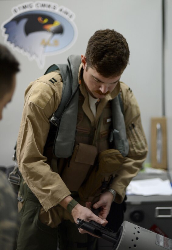 U.S. Air Force Capt. Chris, 391st Expeditionary Fighter Squadron F-15E Strike Eagle weapon system officer, inserts a 15 round 9mm ball magazine into a M9 Beretta at an undisclosed location in Southwest Asia, Dec. 25, 2015. Chris is issued the side arm, along with other survival equipment, prior to each combat sortie in the fight against Daesh. (U. S. Air Force photo by Tech. Sgt. Frank Miller/Released) 