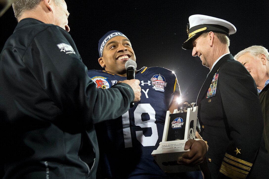 Navy quarterback Keenan Reynolds accepts the Most Valuable Player trophy for Navy’s 44-28 victory over Pittsburgh in the 2015 Military Bowl at Navy-Marine Corps Memorial Stadium in Annapolis, Md., Dec. 28, 2015. DoD News photo by EJ Hersom