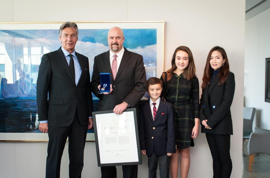 Joint Logistics Operations Center Executive Officer and retired Army Col. Eugene Shearer (second from left) and his family joined Canadian Ambassador to the United States Gary Doer (left) at the Canadian Embassy in Washington, D.C., Dec. 15.  Ambassador Doer presented the Canadian Meritorious Service Medal to Shearer for his service on behalf of Canadians as chief of the Combined Joint Logistics Branch within Regional Command South, Afghanistan, from May 2010 to June 2011. Photo by Keegan Bursaw