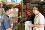 Jonathan Connell, CEO, and Todd Daughtry, COO, co-owners of veteran-owned small business C & C Containers, LLC meet in their Albany, Georgia, warehouse with Georgia PTAC Procurement Counselor Bridget Bennett to discuss product packaging and marking requirements for shipment of medical supplies. Photo courtesy of Georgia Tech