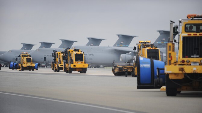 Snow removal vehicles from the 436th Civil Engineer Squadron drive down the flight line during the annual snow parade Nov. 6, 2015, at Dover Air Force Base, Del.  Many members of Team Dover leadership were given the opportunity to ride or drive in the vehicles. (U.S. Air Force photo/Tech. Sgt. Elizabeth Morris)