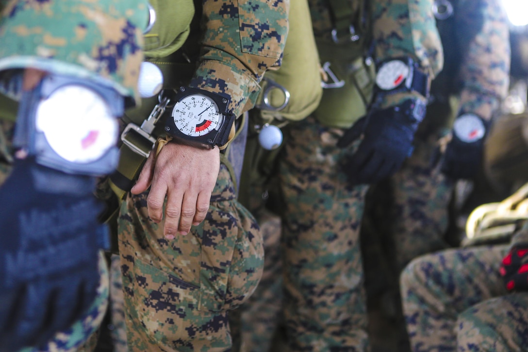 Marines don altimeters before a free fall jump at 10,000 feet above Drop Zone Basilone on Marine Corps Base Camp Pendleton, Calif., Dec.21. Marine Heavy Helicopter Squadron 462 supported the parachute-operations training. Marine Corps Photo by Lance Cpl. Harley Robinson