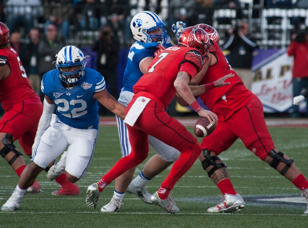 Utah quarterback Travis Wilson tries to avoid being sacked by Brigham Young University linebacker Manoa Pikula during the Royal Purple Las Vegas Bowl at Sam Boyd Stadium in Las Vegas, Dec. 19, 2015. The Utah Utes were victorious over the BYU Cougars 35-28. (U.S. Air Force photo by Senior Airman Thomas Spangler)