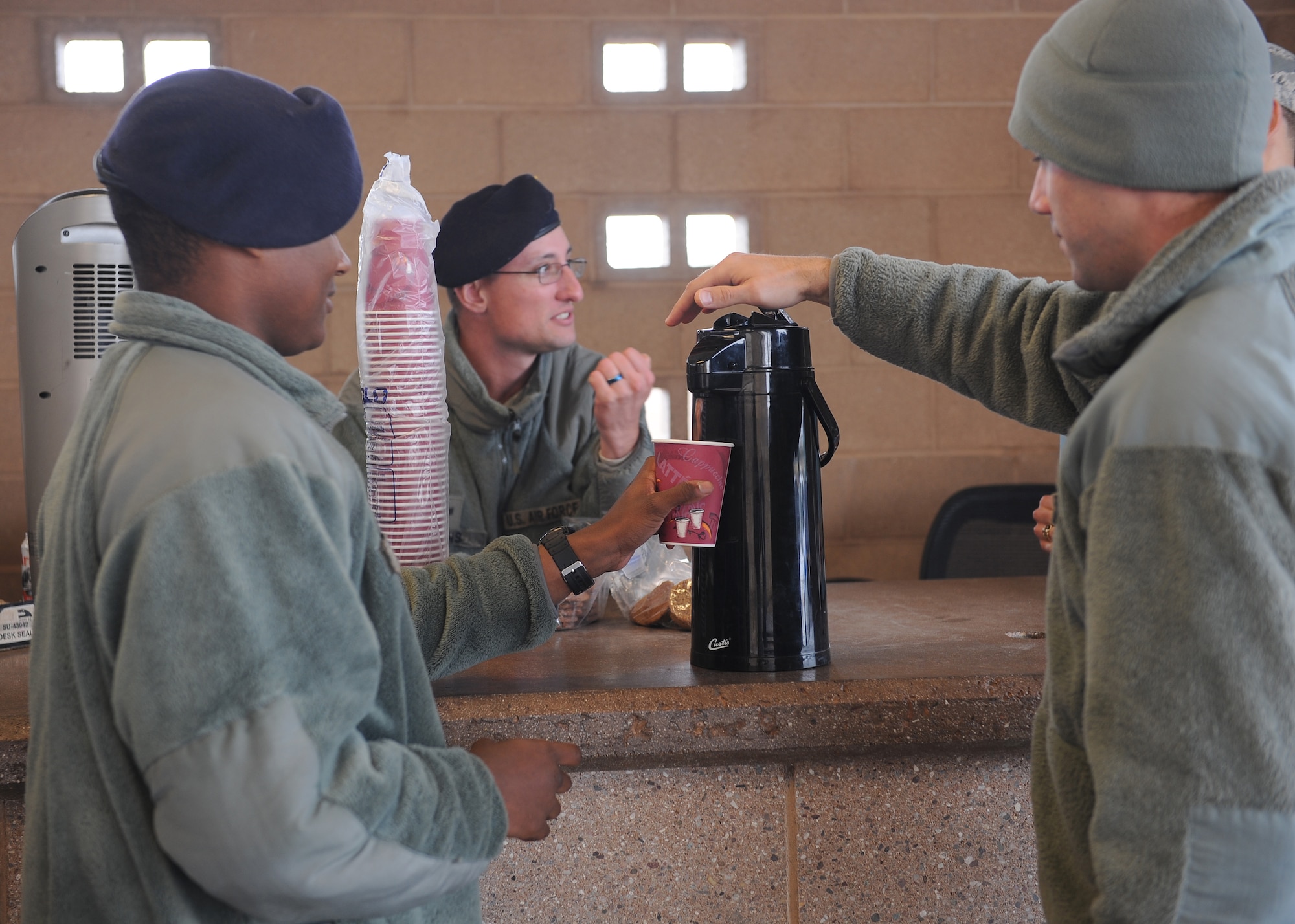 U.S. Air Force Chaplain (Capt.) Justin Szeker, 355th Fighter Wing chaplain, pours Airman 1st Class Michael Massey, 355th Security Forces Squadron, a cup of hot chocolate at Davis-Monthan Air Force Base, Ariz., Dec. 14, 2015. The hot chocolate was provided by the Chaplain Corps and distributed to all SFS Airmen working at entry control points around D-M. (U.S. Air Force photo by Senior Airman Cheyenne A. Powers/ Released)
