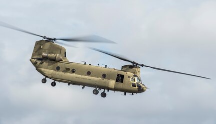 A soldier looks out the window of a CH-47 Chinook from the 3rd Combat Aviation Brigade Dec. 28, 2015 at Joint Base Charleston, S.C. Weapons Station. More than 20 UH-60 Black Hawk helicopters returned to the U.S. from various United States European Command bases via cargo ship. The 841st Transportation Battalion from Joint Base Charleston unloaded the helicopters and the 3rd CAB flew the aircraft back to their home  station, Hunter Army Airfield, Ga.  (U.S. Air Force photo/Senior Airman Jared Trimarchi) 