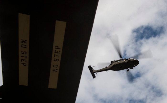 A UH-60 Black Hawk from the 3rd Combat Aviation Brigade flies over a dock Dec. 28, 2015 at Joint Base Charleston, S.C. Weapons Station. More than 20 helicopters returned to the U.S. from various United States European Command bases via cargo ship. The 841st Transportation Battalion from Joint Base Charleston unloaded the helicopters and the 3rd CAB flew the aircraft back to their home  station, Hunter Army Airfield, Ga. (U.S. Air Force photo/Senior Airman Jared Trimarchi) 