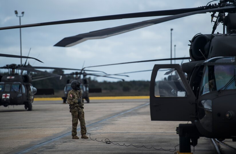 A crew chief from the 3rd Combat Aviation Brigade continues a pre-flight check Dec. 28, 2015 at Joint Base Charleston, S.C. Weapons Station. More than 20 helicopters returned to the U.S. from various United States European Command bases via cargo ship. The 841st Transportation Battalion from Joint Base Charleston unloaded the helicopters and the 3rd CAB flew the aircraft back to their home  station, Hunter Army Airfield, Ga. (U.S. Air Force photo/Senior Airman Jared Trimarchi) 