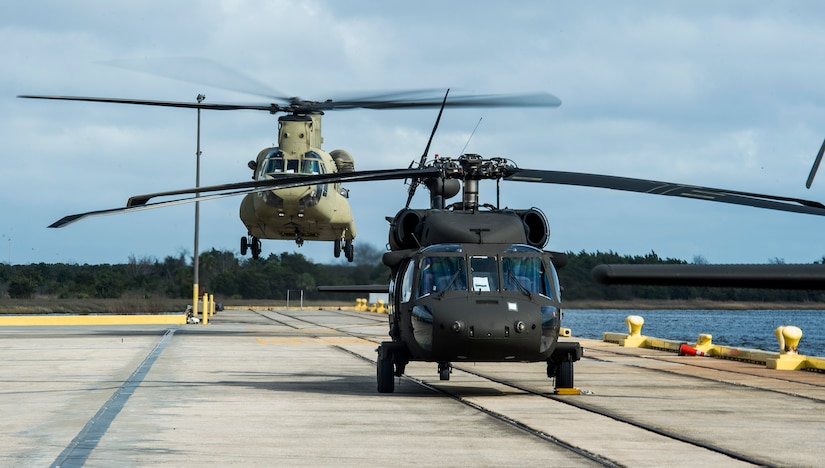 A CH-47 Chinook from the 3rd Combat Aviation Brigade lands behind a UH-60 Black Hawk Dec. 28, 2015 at Joint Base Charleston, S.C. Weapons Station. More than 20 helicopters returned to the U.S. from various United States European Command bases via cargo ship. The 841st Transportation Battalion from Joint Base Charleston unloaded the helicopters and the 3rd CAB flew the aircraft back to their home  station, Hunter Army Airfield, Ga. (U.S. Air Force photo/Senior Airman Jared Trimarchi) 