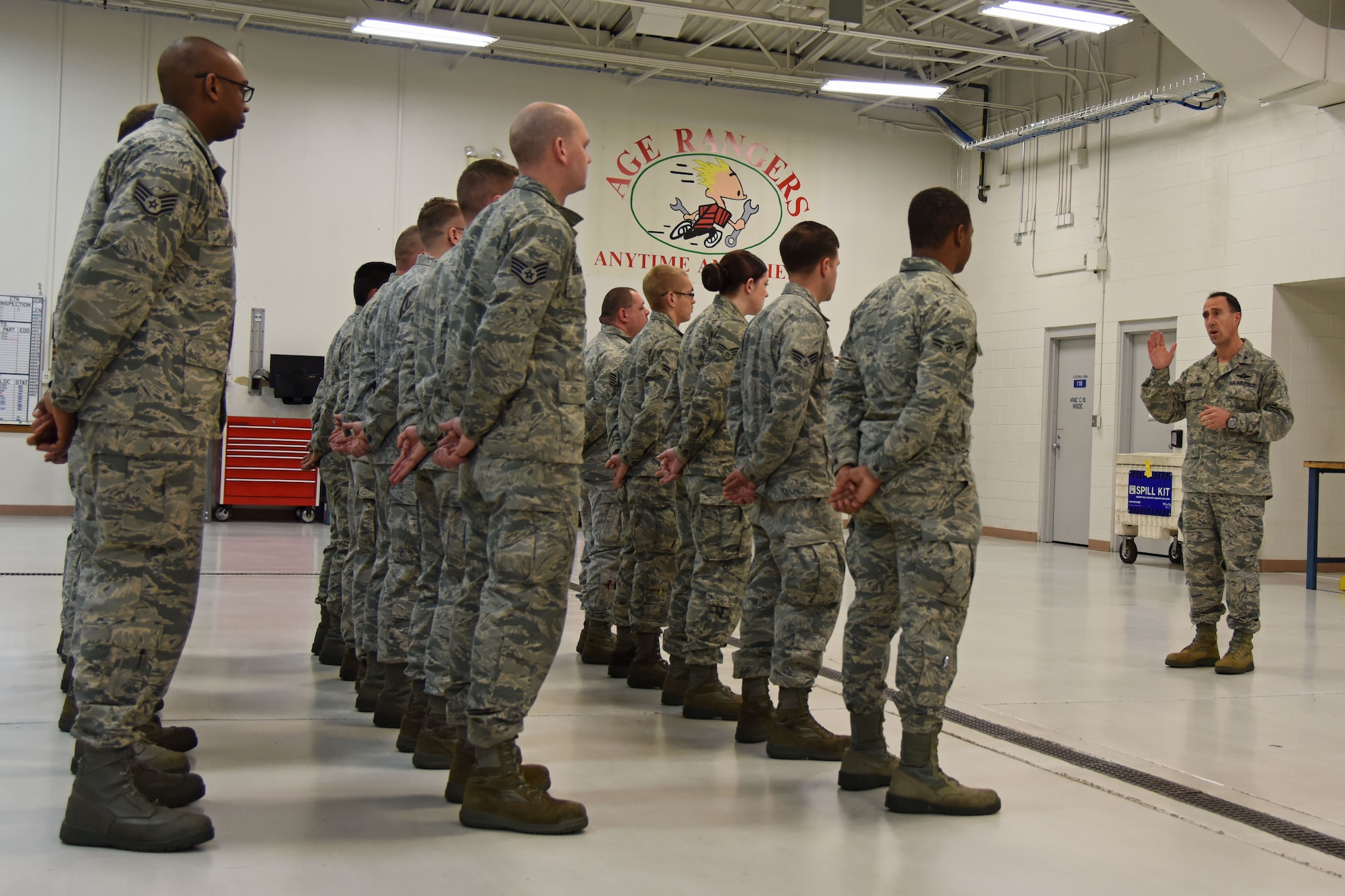 Col. Leonard Kosinski, 62nd Airlift Wing commander, speaks at the aircraft ground equipment facility, December 11, 2015, to one of the 62nd Maintenance Squadron AGE flights about the importance of attention to detail while performing maintenance on and around the McChord Field flight line. Airman 1st Class Brandon Reed’s, 62nd MXS AGE apprentice, attention to detail helped discovered a problem with the pintle hook on his Bobtail vehicle leading to the detection of this same problem on 14 different McChord Field Bobtails. (U.S. Air Force photo/Staff Sgt. Katie Jackson)