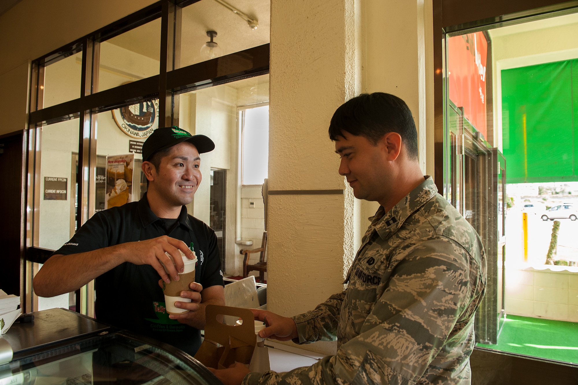 U.S. Air Force Capt. Joshua Caragan, 18th Wing equal opportunity officer, gets coffee from Koji Kamekawa, Daily Grind Coffee Shop cashier, in the Rocker NCO Club, Dec. 30, 2015, at Kadena Air Base, Japan. The Rocker NCO Club is closing its doors to make way for a brand new facility coming in 2017. (U.S. Air Force photo by Airman 1st Class Corey M. Pettis) 