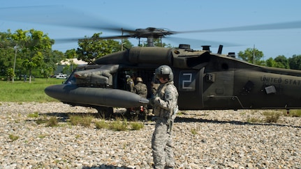 U.S. Army Cpl. Brain McKee, 1-228th Aviation Regiment flight engineer helps Honduran troops load into a U.S. Army UH-60 Blackhawk with their gear Dec. 16, 2015, in the Gracias a Dios Department (state) of Honduras. The mission is a part of the larger Operation CARAVANA, which allows Honduran troops to more easily access areas in the department and better limit the flow of illicit materials and drugs in the area. (U.S. Air Force photo by Capt. Christopher Mesnard/Released)
