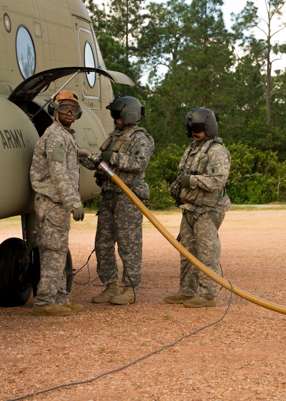 From right, U.S. Army Sgts. David Pressnell and David Uplinger 1-228th Aviation Regiment flight engineers and Spc. Tyree Doyle, Joint Task Force-Bravo Petroleum, Oil and Lubricant specialist refuel a U.S. Army CH-47 Chinook Dec. 17, 2015 at Mocoron Airfield in the Gracias a Dios Department (state) of Honduras. The airfield provides the flying forces a hub to refuel at and embark from when conducting CARAVANA troop movements in the area. The troop movements are part of a combined U.S. and Honduran effort to disrupt the flow of illicit drugs and materials through the region. (U.S. Air Force photo by Capt. Christopher Mesnard/Released)