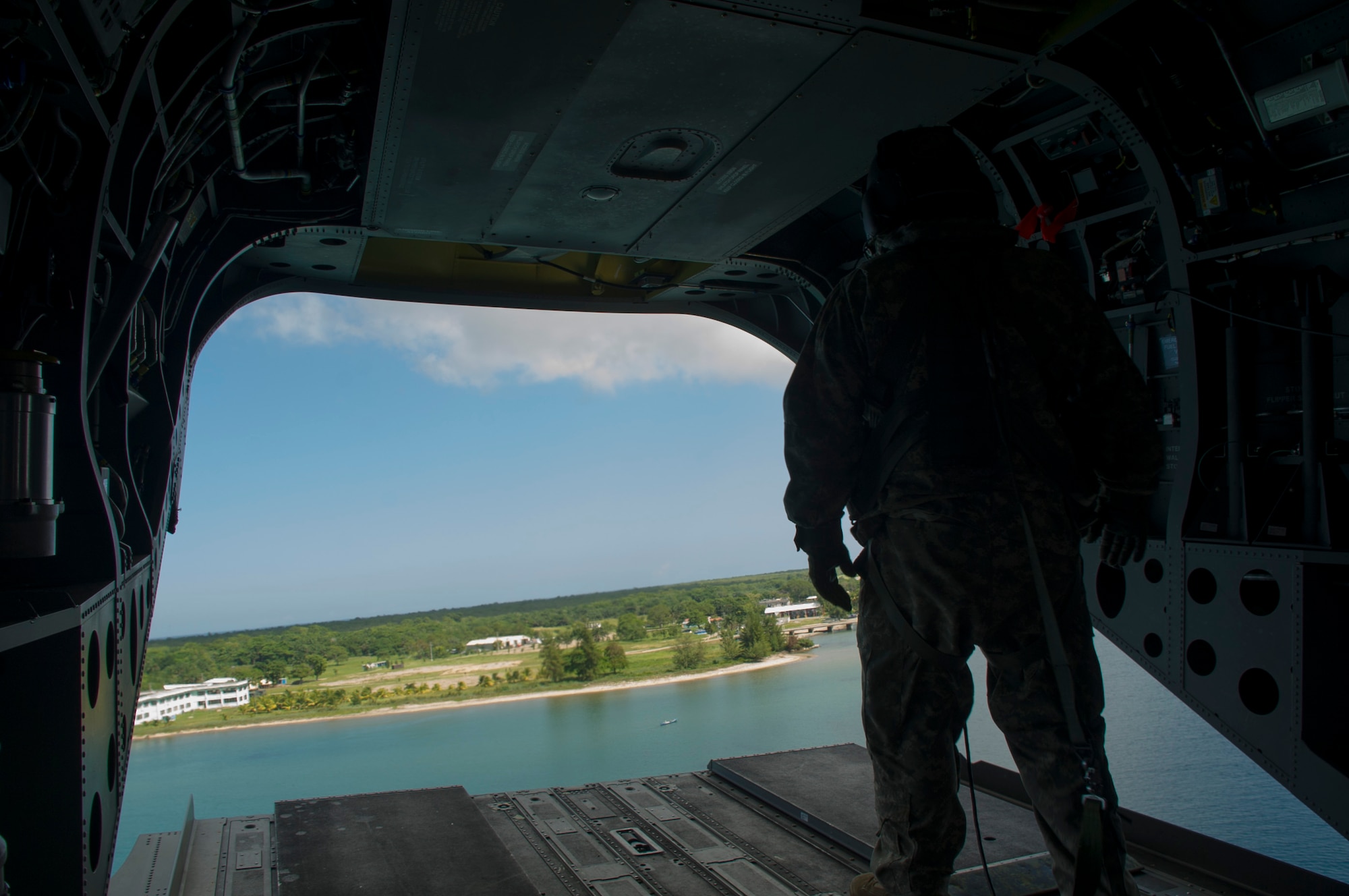 U.S. Army Sgt. David Pressnell, 1-228th Aviation Regiment flight engineer provides visual aid to his fellow U.S. Army CH-47 Chinook aircrew as the helicopter departs a Honduran base Dec. 17, 2015, in the Gracias a Dios Department (state) of Honduras. The CH-47 served as a transport for Honduran troops traveling to and from various outposts in the remote region to help disrupt the flow of illicit materials. (U.S. Air Force photo by Capt. Christopher Mesnard/Released)