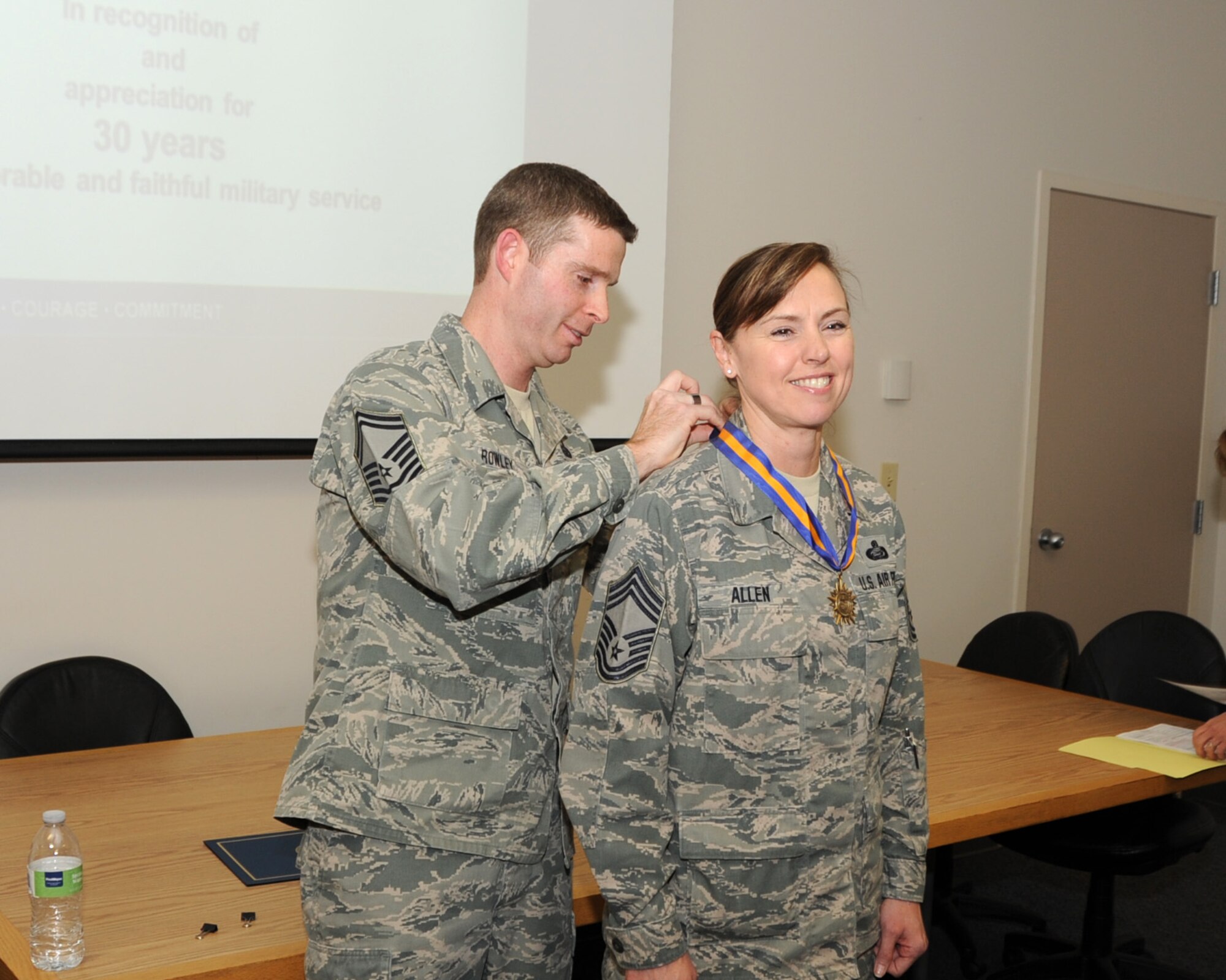 In a surprise presentation during Commander’s Call, Senior Master Sgt. Brion Rowley presents Chief Master Sgt. Jean Allen with the Oregon National Guard 30-year service medal.  Chief Master Sgt. Allen is the Superintendent for the Force Support Squadron, Portland Air National Guard Base, Ore., Nov. 2, 2013. (Air National Guard photo by Master Sgt. Shelly Davison, 142nd Fighter Wing Public Affairs)