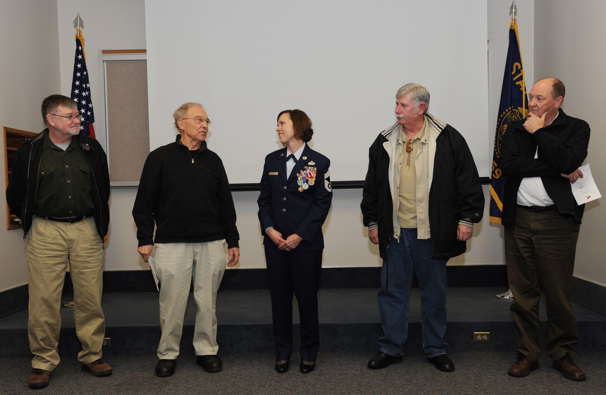 Four retired Oregon Air National Guard Chief Master Sergeants take turns highlighting Chief Master Sgt. Jean Allen, center, career in the Oregon Air National Guard, during her formal retirement ceremony, Dec. 22, 2015, Portland Air National Guard Base, Ore. (Air National Guard photo by Tech. Sgt. John Hughel, 142nd Fighter Wing Public Affairs)