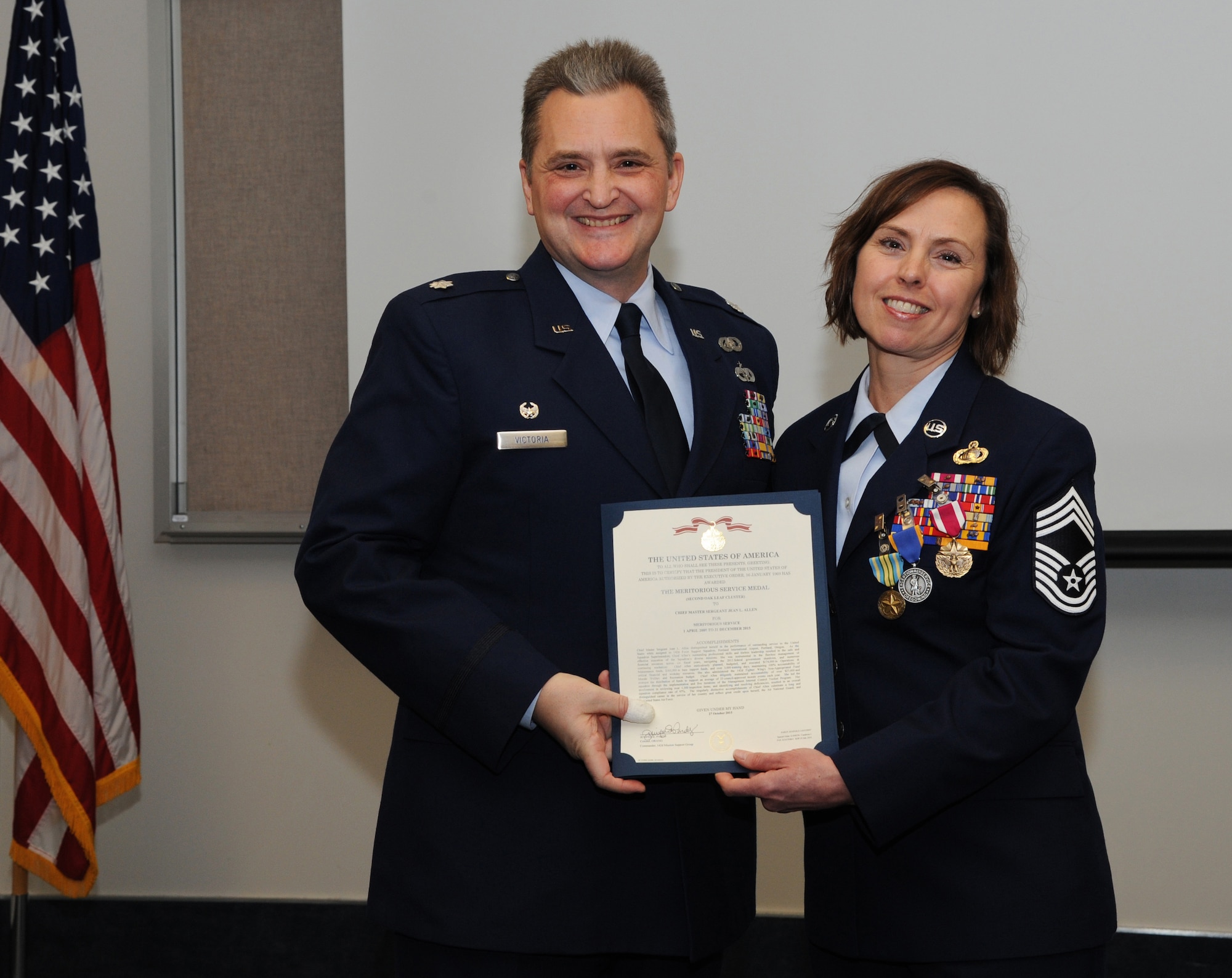 Oregon Air National Guard Lt. Col. Anthony Victoria, 142nd Fighter Wing Force Support Squadron commander, left, presents The Meritorious Service Medal to Chief Master Sgt. Jean Allen, right, during her formal retirement ceremony from the Air National Guard, Dec. 22, 2015, Portland Air National Guard Base, Ore. (Air National Guard photo by Tech. Sgt. John Hughel, 142nd Fighter Wing Public Affairs)