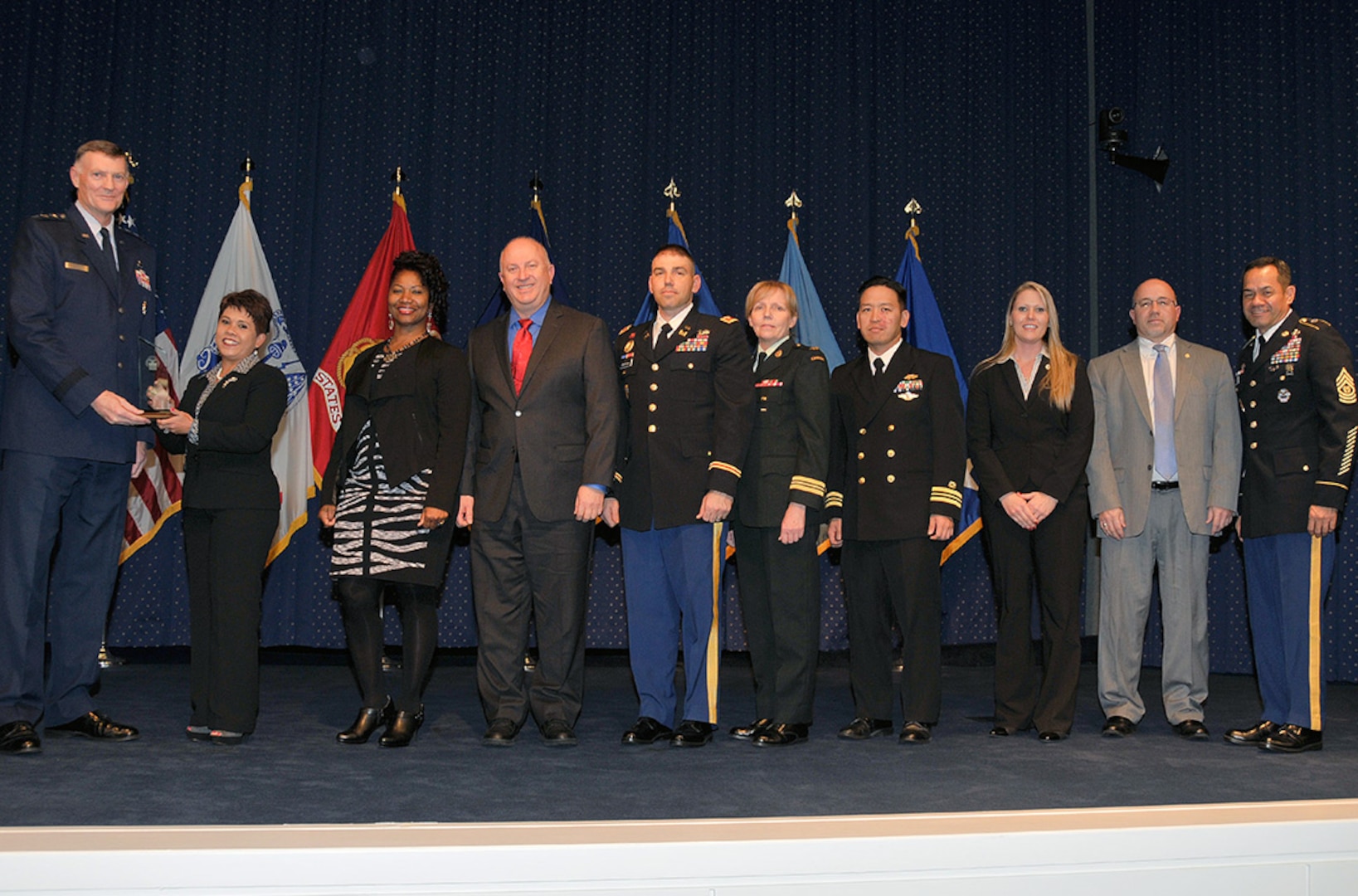 Defense Logistics Agency Director Air Force Lt. Gen. Andy Busch (left) presents the Small Team Performance Award to members of the DLA Logistics Operations’ Joint Contingency Acquisition Support Office, Operation United Assistance Team. The awards were given at the 48th Annual Employee Recognition Program held at the McNamara Headquarters Complex Dec. 10. 