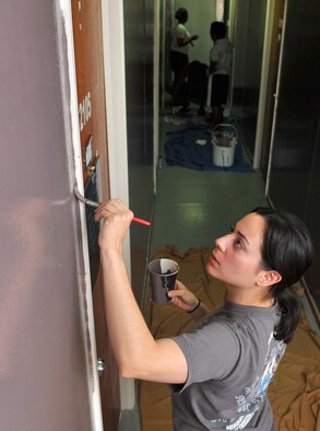 Senior Airman Joan, 380th Expeditionary Security Forces Squadron Force Protection escort, paints the corner of a door frame at an undisclosed location in Southwest Asia, Nov. 19, 2015.  The residents, 380th ESFS FP Airmen, recently completed a month-long dorm renovation project to make their living areas more home-like. (U.S. Air Force photo by Staff Sgt. Kentavist P. Brackin/released)