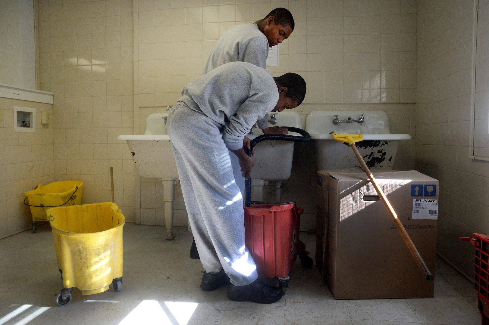 Malachi Ervin, foreground, and Tarvaress Williams, both cadets at the Maryland National Guard’s Freestate ChalleNGe Academy, fill a bucket with hot water while stripping and waxing the floors in the academy’s barracks building, Nov. 17, 2015. Those at the academy learn not only academic skills in preparation for earning either their GED certificate or high school diploma, but also life skills as well. Rather than simply assigning housekeeping duties to cadets, at the Freestate Academy cadets must formally apply and interview with academy staff as a way to prepare them for job interviews. 