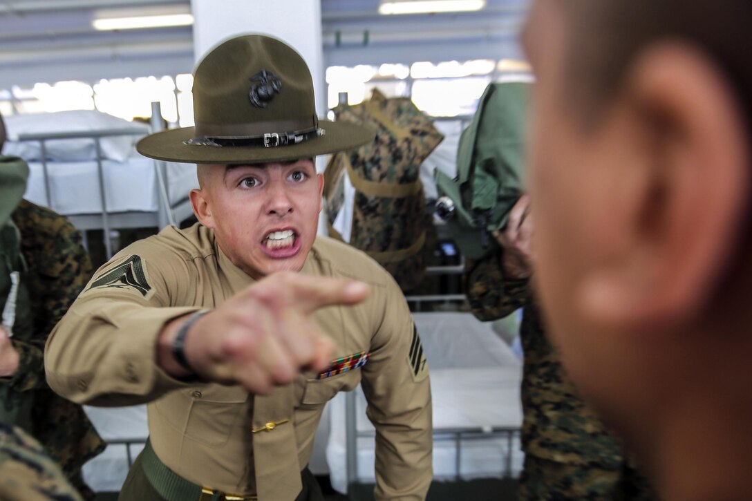 Marine Corps Sgt. Preston T. Brown instructs a recruit to respond louder during pick up at Marine Corps Recruit Depot, San Diego, Dec. 18, 2015. Photo By Marine Corps Sgt. Tyler Viglione
